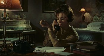 Movie still from “Black Sabbath” (1963), directed by Mario Bava – A woman sitting at a table talking on a phone; Medium shot, High angle