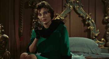Movie still from “Black Sabbath” (1963), directed by Mario Bava – A woman sitting on a bed holding a wine glass; Medium shot, Over the shoulder angle