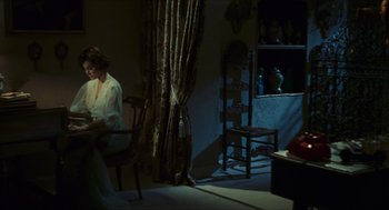 Movie still from “Black Sabbath” (1963), directed by Mario Bava – A woman sitting on a chair in a dark room; Wide shot, High angle