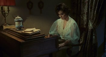 Movie still from “Black Sabbath” (1963), directed by Mario Bava – A woman writing on top of a wooden desk; Medium shot, High angle