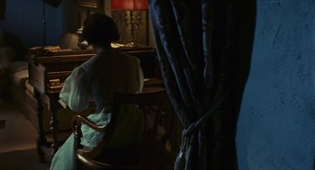 Movie still from “Black Sabbath” (1963), directed by Mario Bava – A woman sitting in a chair in front of a window; Medium shot, Over the shoulder angle