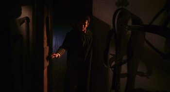Movie still from “Black Sabbath” (1963), directed by Mario Bava – A man standing in a dark room holding a knife; Medium shot, Low angle