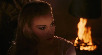 A beautiful woman sitting in front of a fireplace