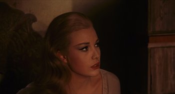 Movie still from “Black Sabbath” (1963), directed by Mario Bava – A beautiful woman with long blonde hair wearing a pink top; Close Up shot, Over the shoulder angle