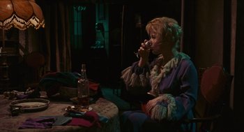 Movie still from “Black Sabbath” (1963), directed by Mario Bava – A woman sitting at a table drinking a glass of wine; Medium shot, High angle