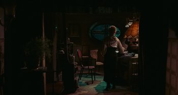 Movie still from “Black Sabbath” (1963), directed by Mario Bava – A woman standing in a dimly - lit living room; Wide shot, High angle
