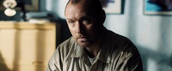Movie still from “Black Sea” (2014), directed by Kevin Macdonald – A person wearing a shirt and looking at the camera; Close Up shot, Low angle