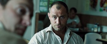 Movie still from “Black Sea” (2014), directed by Kevin Macdonald – A person wearing a white shirt; Close Up shot, Over the shoulder angle