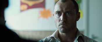 Movie still from “Black Sea” (2014), directed by Kevin Macdonald – A person looking at the camera; Close Up shot, Over the shoulder angle