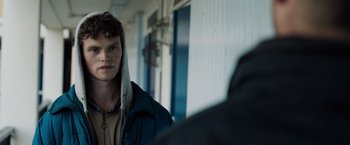 Movie still from “Black Sea” (2014), directed by Kevin Macdonald – A young man wearing a jacket and a hood; Close Up shot, Over the shoulder angle