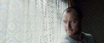 Movie still from “Black Sea” (2014), directed by Kevin Macdonald – A person looking out of a window; Close Up shot, Low angle