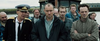 Movie still from “Black Sea” (2014), directed by Kevin Macdonald – A group of men standing next to each other; Medium shot, Low angle