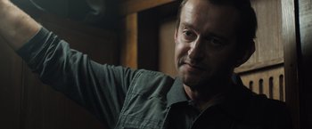 Movie still from “Black Sea” (2014), directed by Kevin Macdonald – A person wearing a shirt; Close Up shot, Over the shoulder angle