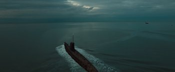 Movie still from “Black Sea” (2014), directed by Kevin Macdonald – A boat in the middle of the ocean under a cloudy sky; Extreme Wide shot, High angle