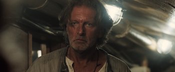 Movie still from “Black Sea” (2014), directed by Kevin Macdonald – A person with long hair; Close Up shot, Over the shoulder angle