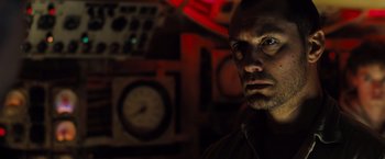 Movie still from “Black Sea” (2014), directed by Kevin Macdonald – A person in a dark room; Close Up shot, Low angle