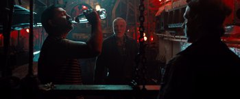 Movie still from “Black Sea” (2014), directed by Kevin Macdonald – A man standing in front of a mirror holding a glass; Medium shot, Over the shoulder angle