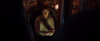 Movie still from “Black Sea” (2014), directed by Kevin Macdonald – A young man is sitting in an underground tunnel; Medium shot, High angle