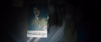 Movie still from “Black Sea” (2014), directed by Kevin Macdonald – A painting of adolf hitler is reflected in a mirror; Extreme Close Up shot, High angle