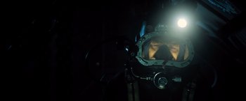 Movie still from “Black Sea” (2014), directed by Kevin Macdonald – A man with a helmet on looking into a mirror; Close Up shot, Low angle