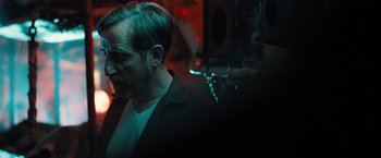 Movie still from “Black Sea” (2014), directed by Kevin Macdonald – A man in a black jacket is smoking a cigarette; Close Up shot, Over the shoulder angle