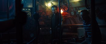 Movie still from “Black Sea” (2014), directed by Kevin Macdonald – A man standing in a room with a lot of lights; Medium shot, Low angle