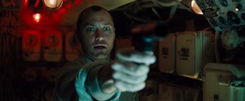Movie still from “Black Sea” (2014), directed by Kevin Macdonald – A man holding a gun in a room; Close Up shot, Low angle