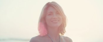 Movie still from “Black Sea” (2014), directed by Kevin Macdonald – A beautiful woman with blonde hair and a pink necklace; Close Up shot, Low angle