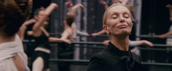 Movie still from “Black Swan” (2010), directed by Darren Aronofsky – A woman in a black shirt is in front of a group of dancers; Close Up shot, Over the shoulder angle