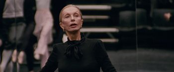 Movie still from “Black Swan” (2010), directed by Darren Aronofsky – An older woman in a black dress looking at the camera; Close Up shot, Low angle