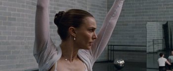 Movie still from “Black Swan” (2010), directed by Darren Aronofsky – A woman with her arms up in the air; Close Up shot, Low angle