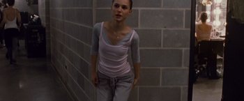 Movie still from “Black Swan” (2010), directed by Darren Aronofsky – A woman standing next to a brick wall; Medium shot, High angle