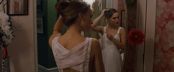 Movie still from “Black Swan” (2010), directed by Darren Aronofsky – A beautiful young lady putting her hair in front of a mirror; Medium shot, Over the shoulder angle