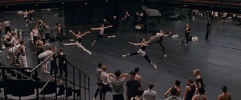 Movie still from “Black Swan” (2010), directed by Darren Aronofsky – A group of people jumping in the air on a stage; Extreme Wide shot, High angle