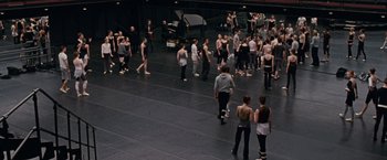 Movie still from “Black Swan” (2010), directed by Darren Aronofsky – A large group of people standing on a stage; Extreme Wide shot, High angle