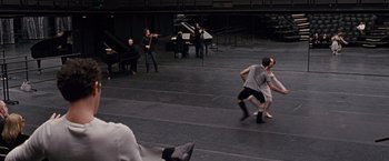 Movie still from “Black Swan” (2010), directed by Darren Aronofsky – A group of young people playing musical instruments in an auditorium; Wide shot, High angle