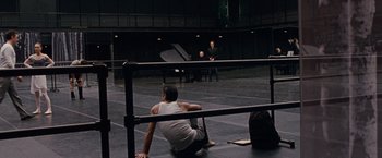 Movie still from “Black Swan” (2010), directed by Darren Aronofsky – A man sitting on the ground in front of two other men; Wide shot, High angle