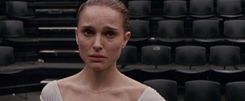 Movie still from “Black Swan” (2010), directed by Darren Aronofsky – A person wearing a white shirt in a room; Close Up shot, Over the shoulder angle