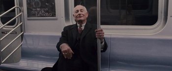Movie still from “Black Swan” (2010), directed by Darren Aronofsky – An older man sitting on a train holding a pole; Medium shot, Low angle