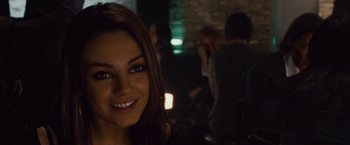 Movie still from “Black Swan” (2010), directed by Darren Aronofsky – A woman smiling for the camera in front of a group of people; Close Up shot, Over the shoulder angle