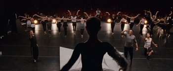 Movie still from “Black Swan” (2010), directed by Darren Aronofsky – A group of people standing on a stage in front of a crowd; Wide shot, Low angle