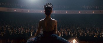 Movie still from “Black Swan” (2010), directed by Darren Aronofsky – A woman in a black dress and a crown in front of an audience; Medium shot, Low angle