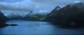 Movie still from “Black Widow” (2021), directed by Cate Shortland – A body of water surrounded by snow capped mountains; Extreme Wide shot, High angle