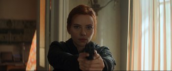 Movie still from “Black Widow” (2021), directed by Cate Shortland – A woman holding a gun in her hand; Close Up shot, Over the shoulder angle