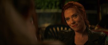 Movie still from “Black Widow” (2021), directed by Cate Shortland – A person sitting at a table; Close Up shot, Over the shoulder angle