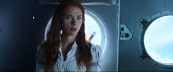 Movie still from “Black Widow” (2021), directed by Cate Shortland – A person wearing a suit and tie; Close Up shot, Low angle