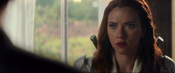 Movie still from “Black Widow” (2021), directed by Cate Shortland – A person sitting in front of a window; Close Up shot, Over the shoulder angle