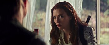 Movie still from “Black Widow” (2021), directed by Cate Shortland – A person with long red hair; Close Up shot, Over the shoulder angle
