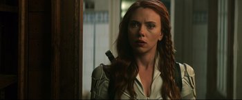 Movie still from “Black Widow” (2021), directed by Cate Shortland – A woman holding a knife in her mouth; Close Up shot, Over the shoulder angle