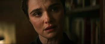 Movie still from “Black Widow” (2021), directed by Cate Shortland – A woman's face in a dark room; Close Up shot, Over the shoulder angle